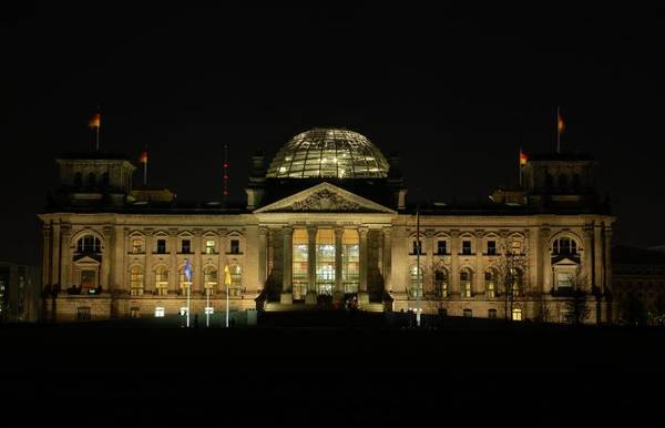 Das nachts beleuchtete Reichstagsgebäude mit gläserner Kuppel in Berlin